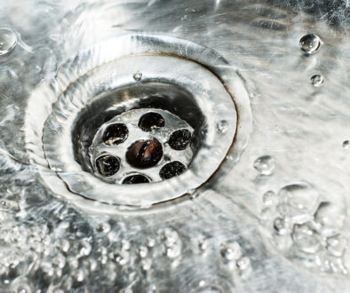 Stainless steel sink plug hole close up with water
