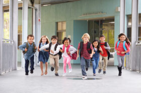 Group of elementary school kids running in a school corridor