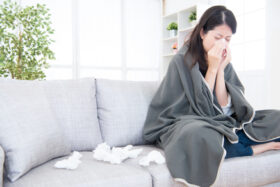 Sick Young Woman Sneeze At Home