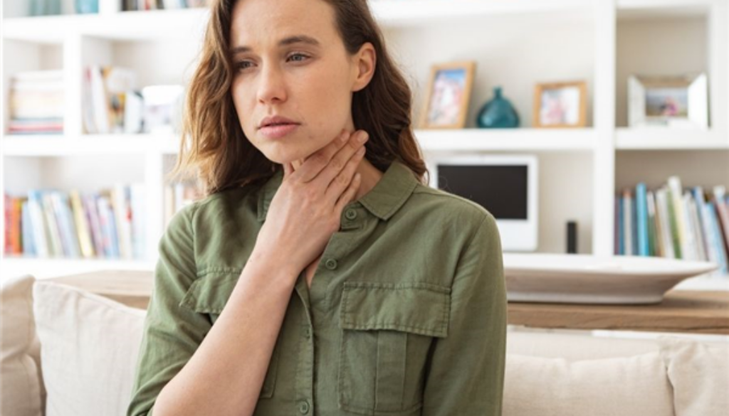 Woman Holding Her Throat Worried About What Are Tonsil Stones