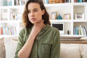 Woman Holding Her Throat Worried About What Are Tonsil Stones