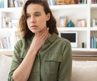 Woman Holding Her Throat Worried About What Are Tonsil Stones