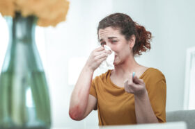 A Woman Blowing Her Nose Suffering From a Dry Nose How to Fix Nasal Dryness